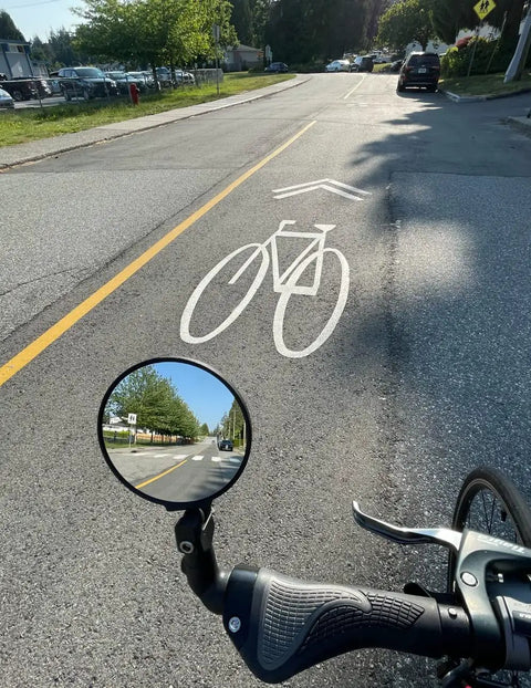 Big Bar End Mirror For E Bikes With Automotive Grade Glass Delivers Crystal Clear View On Left Or Right Fits Most 14.8 To 23 Mm Handlebars showing road view.