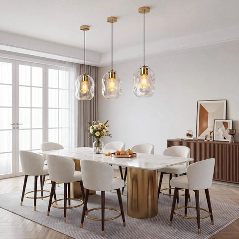 3 Pack Gold Pendant Lights For Kitchen Island Featuring 8.7 Inch Hand Blown Clear Art Glass Globes above a modern dining table