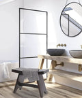 Modern bathroom with a black 24-Inch Teak Shower Bench With Anti-Slip Flared Legs And Adjustable Foot Pads, placed beside a large bathtub.