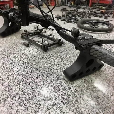 Plug-And-Play Handlebar Mounted Bike Repair Stands Pair, black, on a bike handlebar, 25kg load, fits 30-35mm handlebars on table.