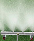 Detail of Grime Busting 16 Inch Pressure Washer Undercarriage Cleaner spraying water on grass