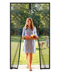 Woman walks through Magnetic Screen Door Mesh With Super Strong Magnets No Sweat Install Fits 36 By 80 Inch Doors, lets fresh air in.