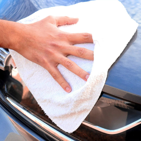 Hand using Heavy Duty Terry Cloth Rags For Cleaning, Absorbent Quick Dry Bar Mops on car surface, 5 Lb White Pack for garage