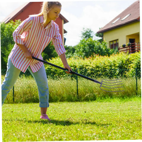 Person using Heavy Duty Manure Fork For Farm And Lawn Care A Real Workhorse Multi Functional Pitch Fork in a garden