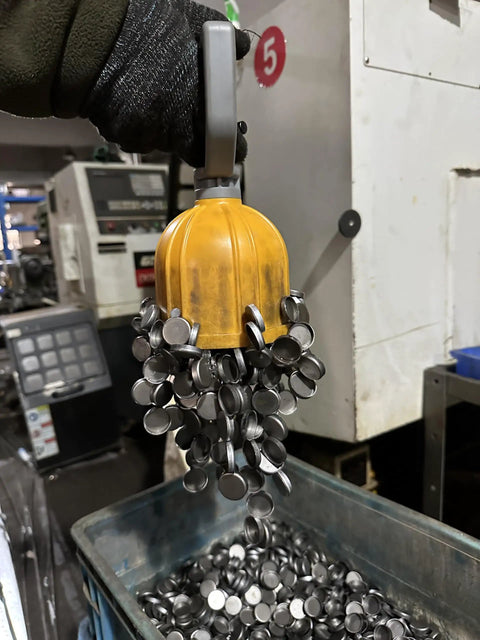 Powerful Magnetic Pickup Tool With Quick Release Lifter capturing metal discs in industrial setting