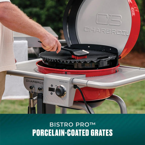 Person cleaning grate on 3-In-1 Dual Fuel Outdoor Grill And Griddle With Electric And Charcoal Modes Pro Bistro Style Cooker