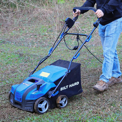 Man using a 16 Inch Dethatcher And Scarifier For Lawn, Electric Walk Behind Tool With 15 Amp Copper Motor on grassy lawn