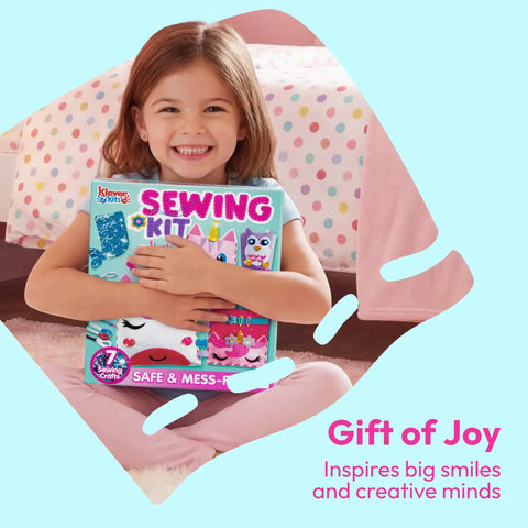 Smiling girl holding Kids Sewing Kit For Beginners: 6 Easy Projects Like Unicorn And Mermaid Pillows, sitting on bed.