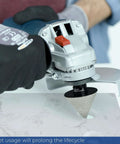 Side view of a 2-inch diamond beveling chamfer bit mounted on a handheld grinder beveling a porcelain tile edge.