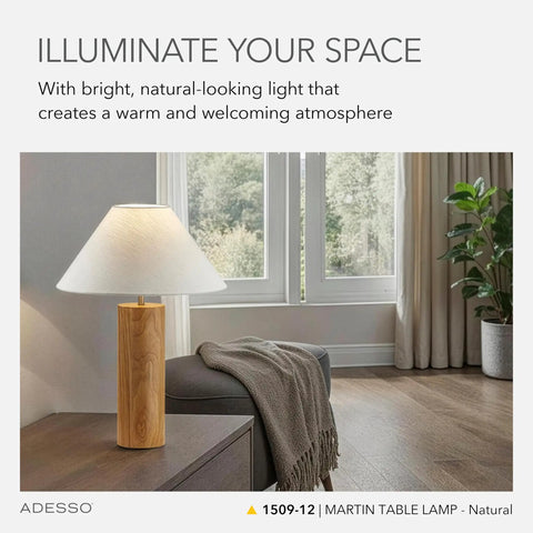 Modern Rustic Table Lamp With Natural Oak Wood Base And White Fabric Shade Antique Brass Accents For A Cozy Warm Glow Bedside Table Home Office Or Living Room Decor Vibe placed in a living room with a view of large windows and curtains.
