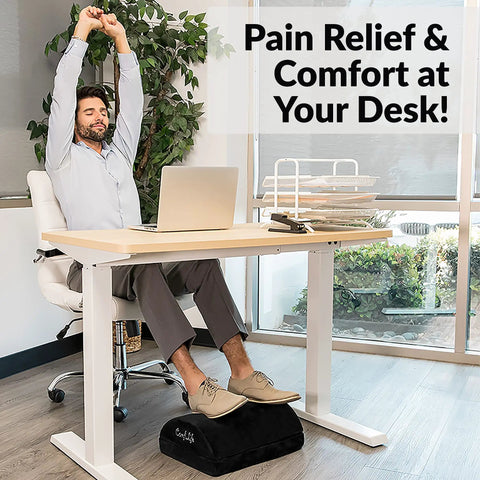 Person using Under Desk Foot Rest For Pain Relief And All Day Comfort, Adjustable Memory Foam Foot Stool under a desk.