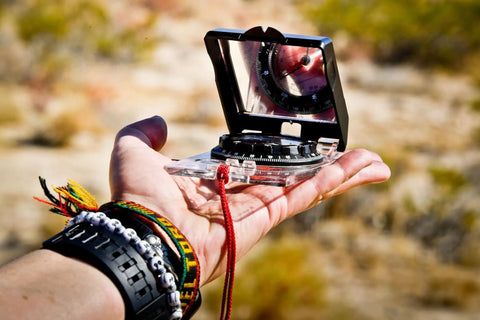 Person holding Advanced Mirror Compass For Pros And Serious Hikers With Metric UTM Scales And Inch Ruler in outdoor setting