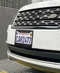 Front view of a white SUV with a matte black license plate frame set for your ride, 2 hole solid aluminum car plate holder, universal fit, installed.