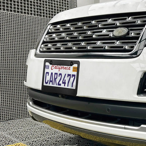 Front view of a white SUV with a matte black license plate frame set for your ride, 2 hole solid aluminum car plate holder, universal fit, installed.