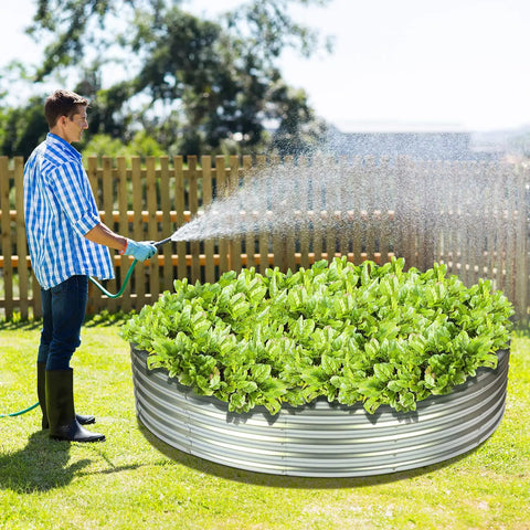 Man watering plants in round galvanized raised garden bed 4x4x1ft outdoor planter for vegetables and flowers durable steel