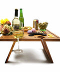 Portable Wine Picnic Table in Acacia Wood With Larger Foldable Tray Charcuterie Board Surface, holding wine and snacks