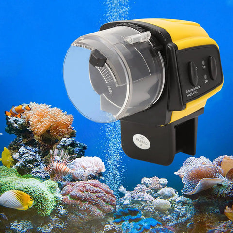 Keep Your Finned Friends Chowing Down Without The Sweat Using This Digital Automatic Fish Food Feeder With A Smart Timer Dispenser For Worry Free Travel Days, yellow automatic fish feeder on aquarium background.