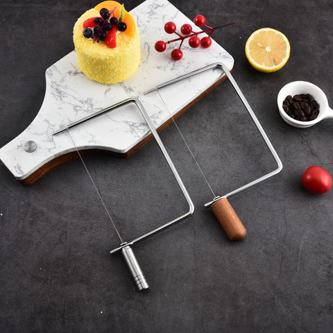 Top Shelf Cheese Slicer Kit With Kickass Stainless Steel Wires And Slick Wood Handles Plus Assembly Hex Key And Replacement Parts For Nifty DIY Cheese Board Crafting Sets displayed on a marble board.