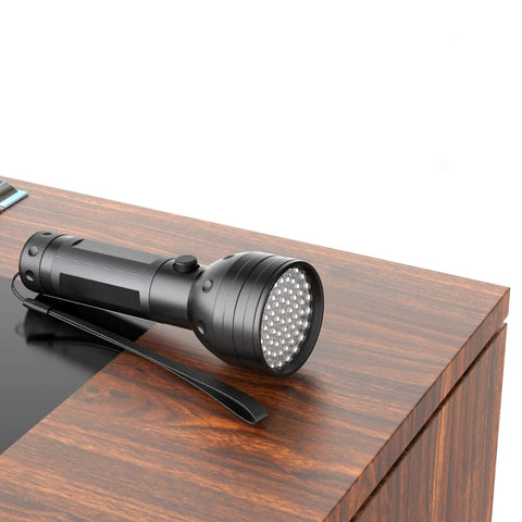 Ultraviolet Blacklight Flashlight With 51 LEDs, 395 Nanometer UV Light resting on wooden surface
