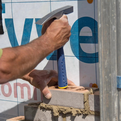 Worker using 20 Oz Masonry Hammer With Forged Steel Construction And Shock Reduction Grip Pro Grade Workhorse Bricklaying Tool