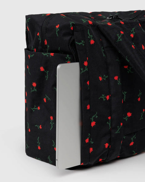 Underseat Travel Carry On Bag Built With Recycled Nylon Small Cloud Style Painted Wildflower Fits Under Airplane Seat And On Top Of Rollers Exterior Pockets For Quick Access Washable And Lightweight showing exterior pocket with laptop