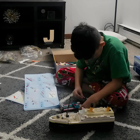 Child building the Epic Titanic Model Kit With 2022 Building Blocks, Giant 26.97 Inch Replica Ship, STEM 3D Puzzle Toy