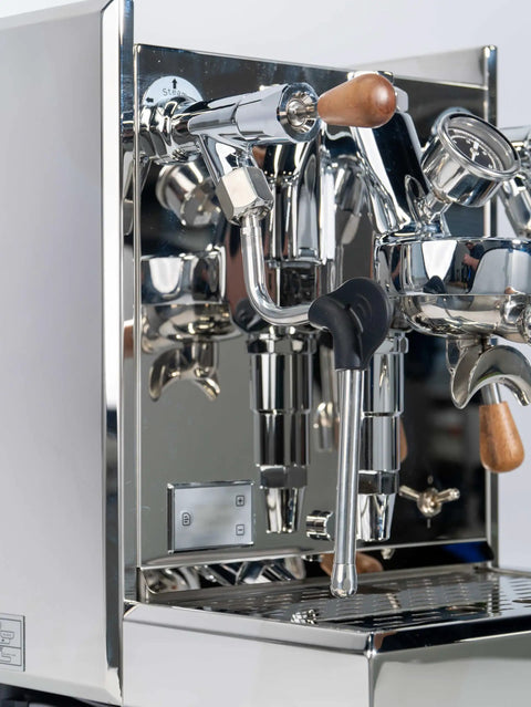 Close-up of Pro Grade Dual Boiler Espresso Maker With PID Precision Tuning, stainless steel frame, steam wand, brew head.