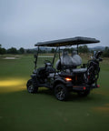 Sleek Black 4-Seater Electric Golf Cart With Raised Stance, Heavy Duty Shocks, Plug And Play Charging, Flex Cargo Trunk, 44 Mile Range Weekend Warrior Build For Parks And Hotel Runs parked on green grass.