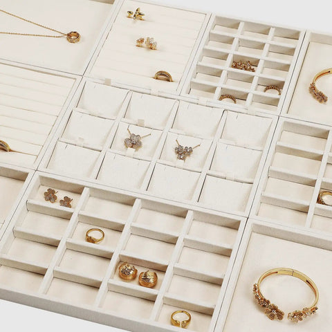 Totally Sweet Beige Linen Jewelry Display Tray With Sixteen Grid Slots For Rings Necklaces And Bracelets Ultra Soft Fabric Organizer showcasing various compartments filled with rings and earrings.