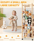 Child holding teddy bear next to Extra Large Stuffed Animal Zoo Organizer With Wheels For Kids Rooms And Playrooms, full of plush toys.