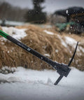 Person using Heavy Duty Pick Mattock With Forged Steel Head And Solid Fiberglass Core, Ergonomic No Slip H Grip Handle on snow