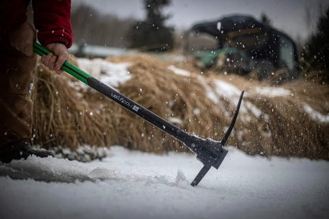 Person using Heavy Duty Pick Mattock With Forged Steel Head And Solid Fiberglass Core, Ergonomic No Slip H Grip Handle on snow