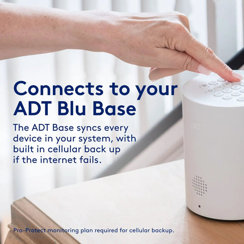 Hand pressing ADT Blu Base security device for synchronizing home security systems with cellular backup.