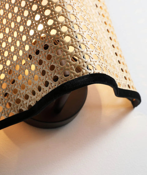 Close-up of Mid Century Bohemian Wall Sconce Lamp with Rattan Shade and Velvet Rim, cozy ambient lighting, beige color.