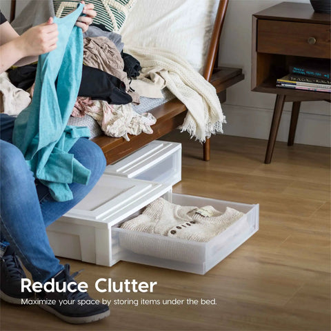 Under Bed Storage Organizer Set With 27 Qt Plastic Stackable Bins And Sliding Drawers, 4 Pack, in use under a bed with clothes.