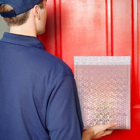 Rose Pink Holographic Padded Mailers 25x30cm Self Seal held by person in blue in front of a red door