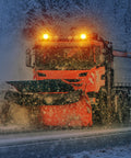 Magnetic cordless beacon lights on orange snowplow truck cab, front view with two amber strobes.