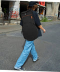 Person walking with Heavy Duty Oxford Fabric Snare Drum Carry Pouch With Spacious Accessory Compartments outdoors.