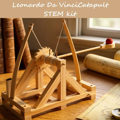 Leonardo Da Vinci Catapult Kit Build a Working Wooden Siege Engine on a table with plans and books in the background.