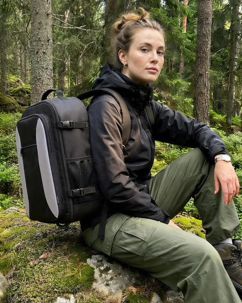 Person outdoors with black TSA Friendly Carry On Travel Backpack for Men and Women With 180 Degree Full Opening Waterproof Pocket.