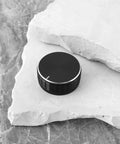 One aluminum alloy potentiometer knob for 6.0mm shaft on stone surface, 40mm diameter, 17mm tall, black dope grip