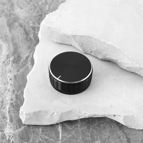 One aluminum alloy potentiometer knob for 6.0mm shaft on stone surface, 40mm diameter, 17mm tall, black dope grip