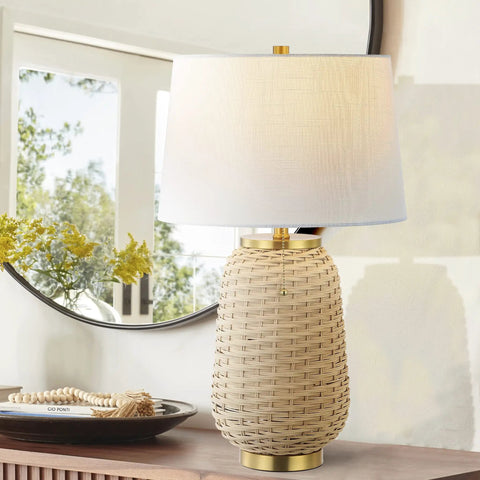 Brass Gold And Light Brown Rattan LED Table Lamp With White Linen Shade, 25 Inches Tall, on a wooden console near a mirror.