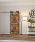 Height Adjustable Floor Lamp With Elongated Fabric Shade In Brushed Nickel Finish beside a barn door in a modern living room.