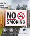 No Smoking Sign 10 By 14 Inch Aluminum Sign With Screen Printed Symbol 40 Mil Laminated Rustproof Aluminum For Indoor Outdoor Use Made In USA Easy Mount With Corner Holes displayed with weather icons, mounted on fence against two backgrounds.