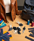 6 Piece Black Universal Zipper Repair Kit With Quick Fix Sliders For No Tool Needed Replacement, displayed with jackets and bags.