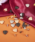 Hassle Free 15 Piece Heart Shaped Leather Rivets Kit Dope Alloy Studs And Screws scattered over fabric.