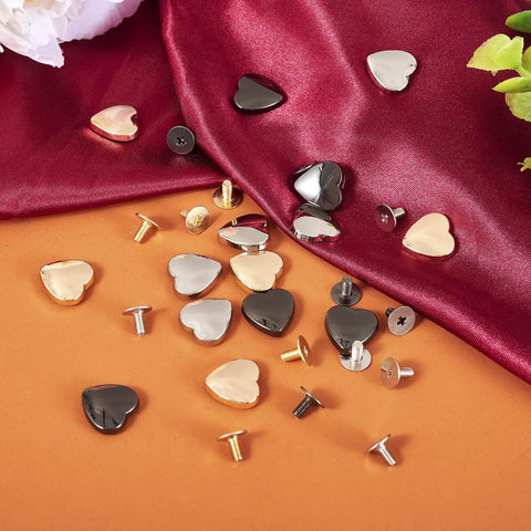 Hassle Free 15 Piece Heart Shaped Leather Rivets Kit Dope Alloy Studs And Screws scattered over fabric.