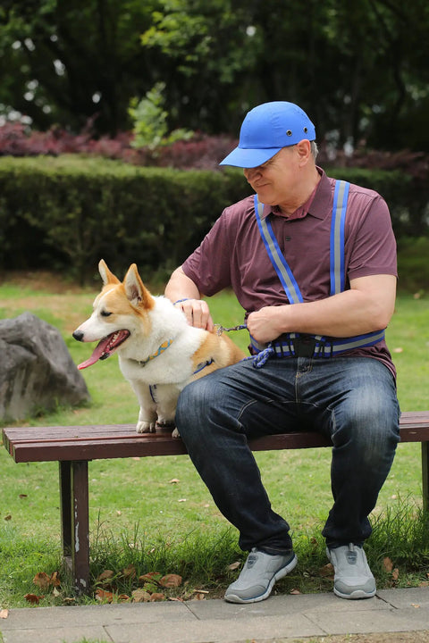 Man wearing a reflective bump cap hard hat, sitting on a bench with a dog, showcasing outdoor use.