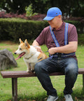 Man wearing blue Baseball Bump Cap Hard Hat Helmet with dog sitting on a bench in park